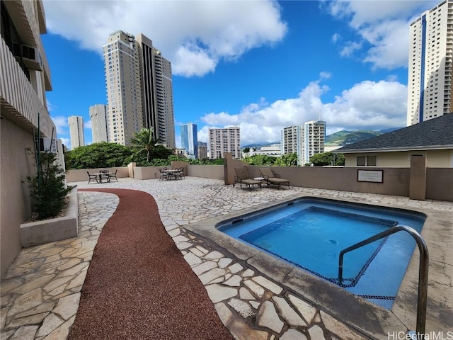 view of swimming pool with a patio and a hot tub