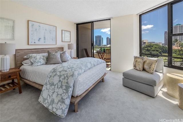 bedroom featuring carpet flooring, access to exterior, expansive windows, and multiple windows