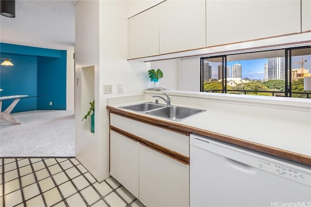 kitchen featuring white cabinets, dishwasher, light colored carpet, and sink