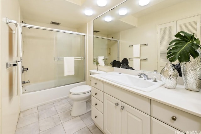 full bathroom featuring tile patterned flooring, vanity, bath / shower combo with glass door, and toilet