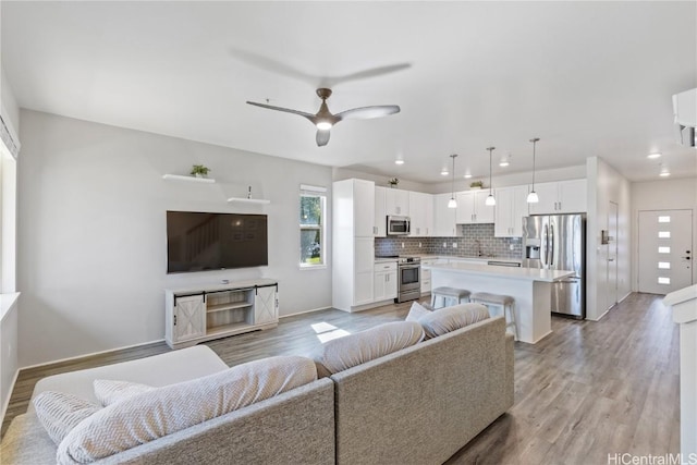 living room featuring light hardwood / wood-style flooring and ceiling fan