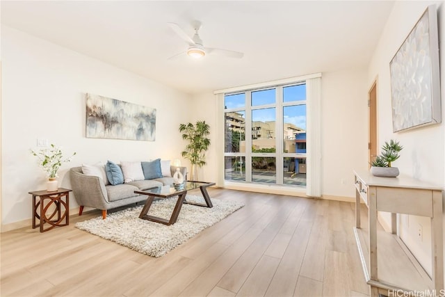 living room with expansive windows, light hardwood / wood-style flooring, and ceiling fan