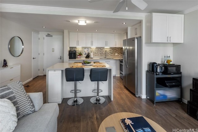 kitchen featuring stainless steel fridge, white cabinetry, a kitchen island, and sink