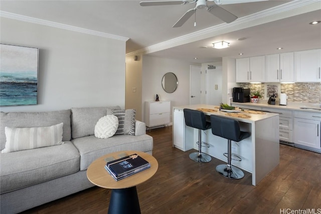 living room with sink, ceiling fan, dark hardwood / wood-style flooring, and crown molding