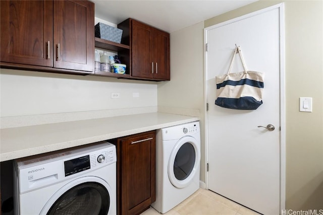 washroom featuring cabinets, light tile patterned floors, and washing machine and clothes dryer