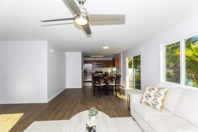 living room featuring ceiling fan and dark hardwood / wood-style flooring