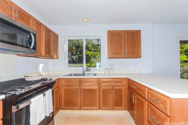 kitchen featuring stainless steel appliances, kitchen peninsula, and sink