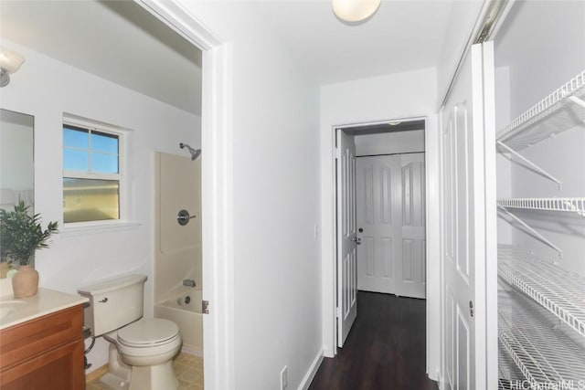 full bathroom featuring hardwood / wood-style floors, vanity, bathing tub / shower combination, and toilet