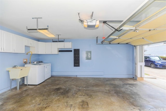 garage with a garage door opener, electric panel, and washer and dryer