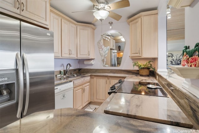 kitchen featuring white dishwasher, sink, stainless steel refrigerator with ice dispenser, ceiling fan, and range