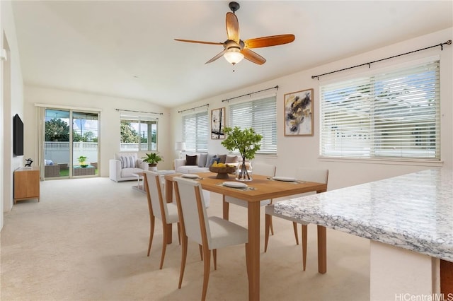 carpeted dining room featuring ceiling fan and vaulted ceiling