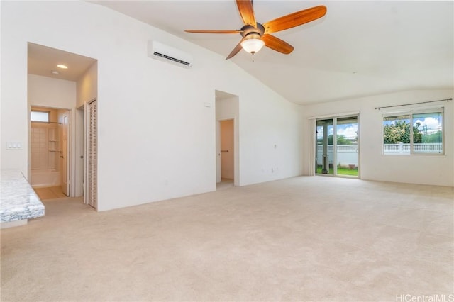 empty room with lofted ceiling, ceiling fan, light colored carpet, and a wall mounted air conditioner