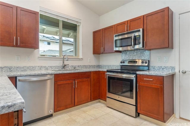 kitchen with light stone countertops, sink, and appliances with stainless steel finishes