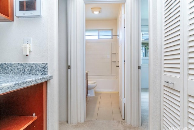 full bathroom with tiled shower / bath, tile patterned flooring, vanity, and toilet