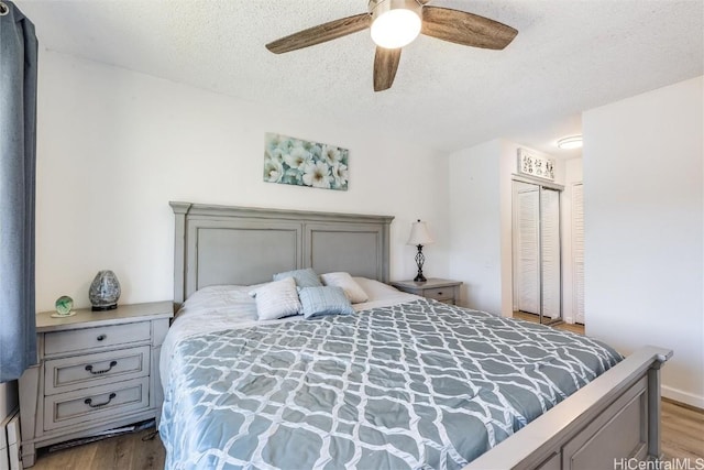 bedroom with ceiling fan, a closet, a textured ceiling, and light wood-type flooring