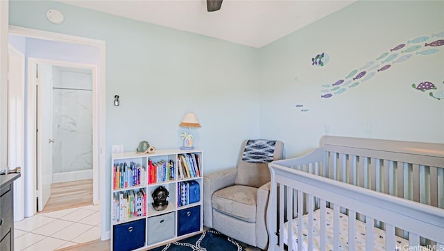 bedroom featuring a nursery area and ceiling fan