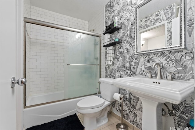 full bathroom featuring bath / shower combo with glass door, tile patterned flooring, toilet, and wallpapered walls