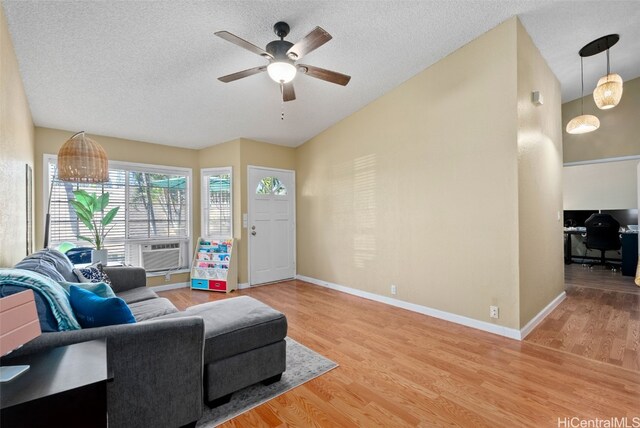 living room with hardwood / wood-style floors, ceiling fan, and a textured ceiling