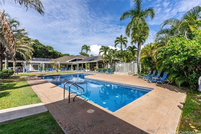 pool with a patio area and fence