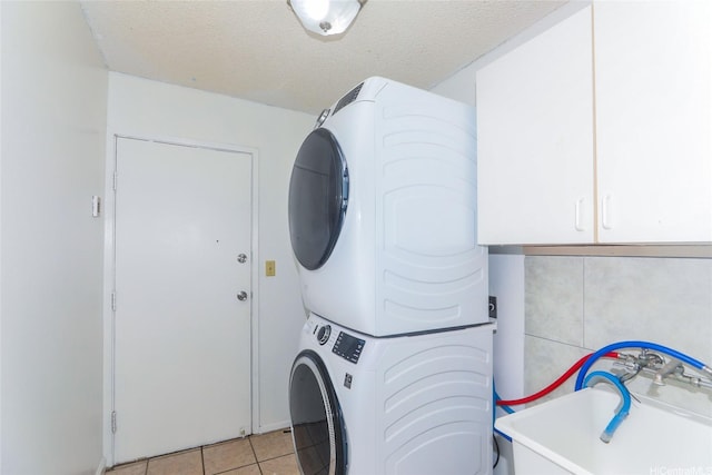 94-15 Kaweo Pl, Mililani, HI 96789 - laundry area with stacked washer / dryer, light tile patterned floors, cabinet space, and a textured ceiling