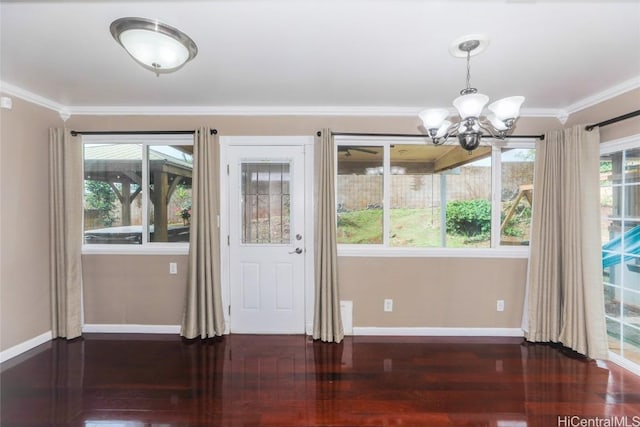 doorway featuring crown molding, a chandelier, and dark hardwood / wood-style floors