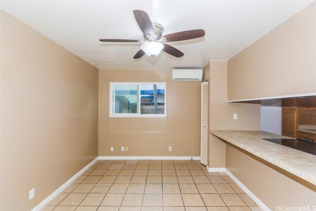 empty room featuring ceiling fan, light tile patterned floors, and a wall mounted AC