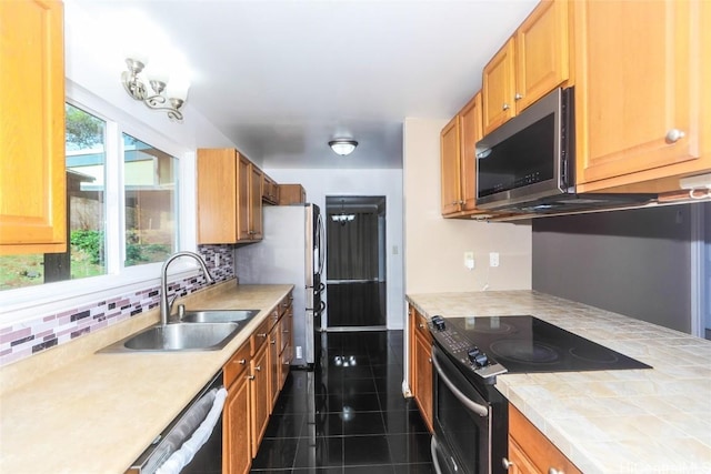 kitchen featuring backsplash, dishwasher, sink, and black / electric stove