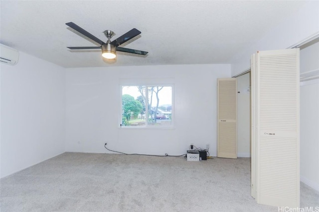 carpeted empty room featuring ceiling fan and a wall mounted air conditioner