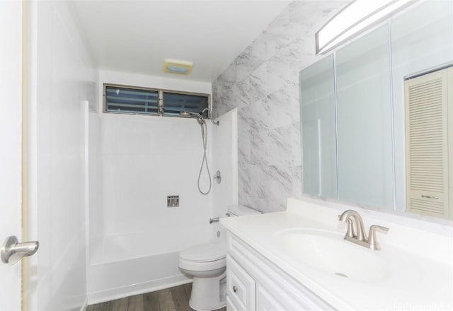 full bathroom featuring vanity, hardwood / wood-style flooring, toilet, tile walls, and shower / bathtub combination