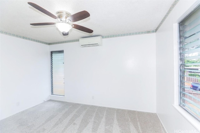 unfurnished room with carpet floors, a wall unit AC, and ceiling fan