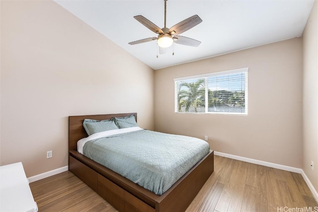 bedroom featuring light wood-type flooring, baseboards, vaulted ceiling, and a ceiling fan