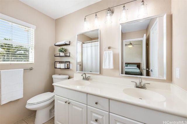 bathroom with toilet, double vanity, a sink, and tile patterned floors