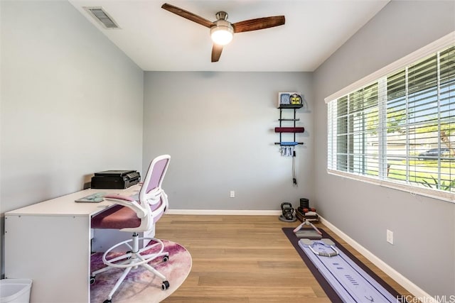 office space with a ceiling fan, visible vents, light wood-style flooring, and baseboards