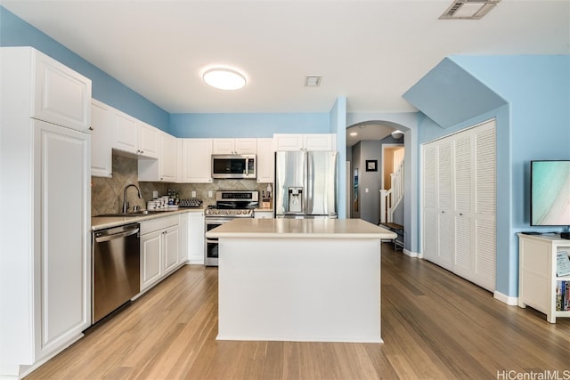 kitchen with visible vents, white cabinets, stainless steel appliances, light countertops, and a sink