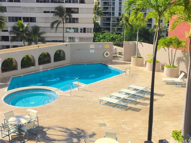 view of pool with a hot tub and a patio