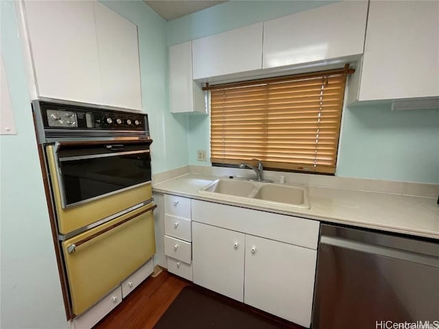 kitchen with white cabinetry, dishwasher, wall oven, and sink