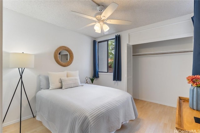 bedroom with a closet, a textured ceiling, a ceiling fan, and wood finished floors