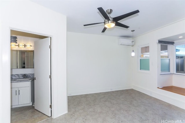 spare room featuring baseboards, a wall mounted air conditioner, ceiling fan, and a sink