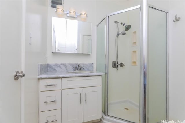 full bath with a stall shower and vanity