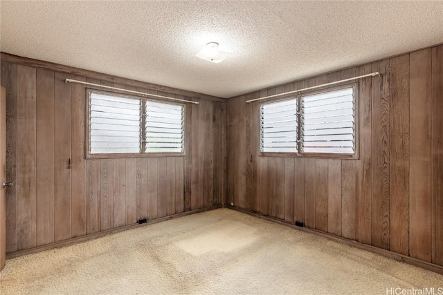 empty room with a textured ceiling and wooden walls