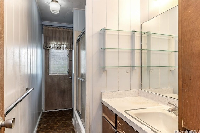 bathroom with vanity, wood walls, parquet flooring, and walk in shower