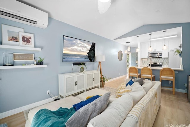 living room with a wall mounted air conditioner, light hardwood / wood-style floors, vaulted ceiling, and ceiling fan