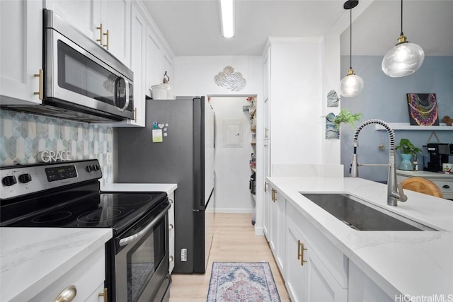 kitchen with pendant lighting, sink, white cabinetry, and stainless steel appliances