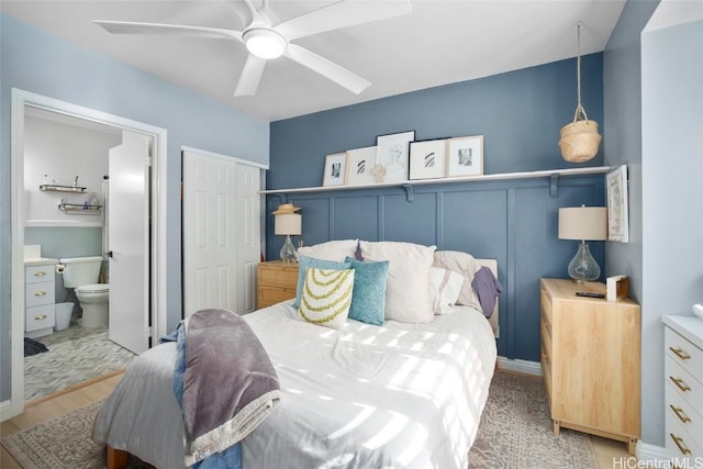 bedroom with hardwood / wood-style floors, a closet, ensuite bath, and ceiling fan