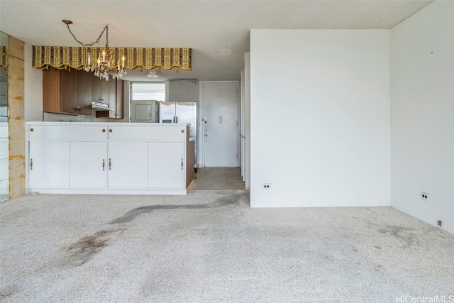 kitchen with light colored carpet, decorative light fixtures, a notable chandelier, and white cabinets