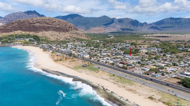 aerial view featuring a view of the beach and a water and mountain view