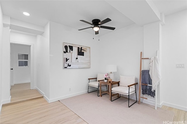 living area featuring light hardwood / wood-style floors and ceiling fan