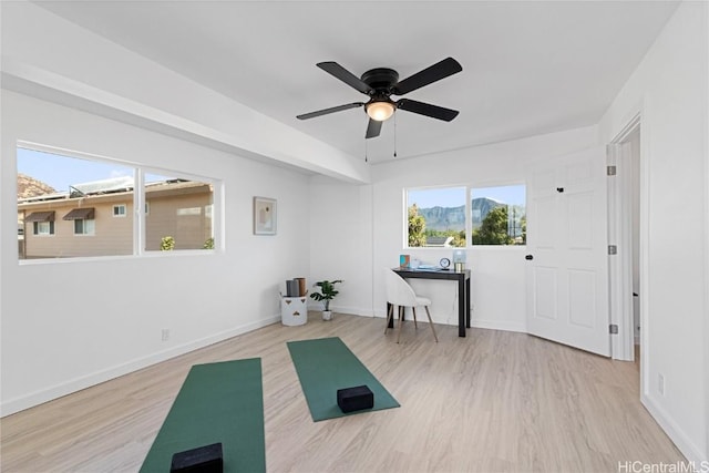 workout area featuring light hardwood / wood-style floors and ceiling fan