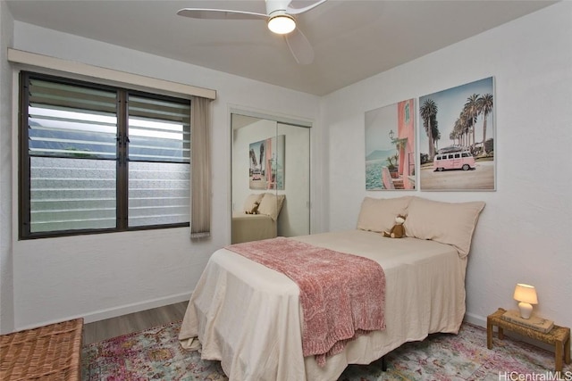 bedroom with ceiling fan, wood-type flooring, and a closet