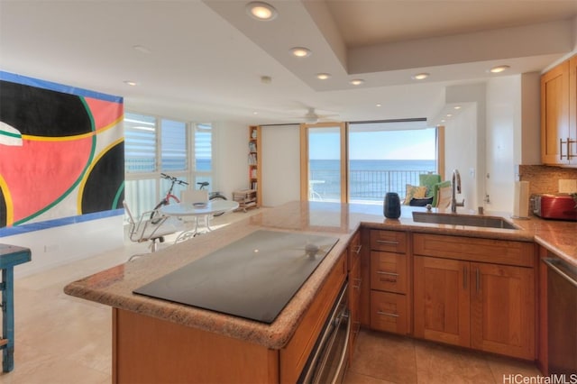 kitchen with black electric stovetop, a water view, sink, stainless steel dishwasher, and kitchen peninsula